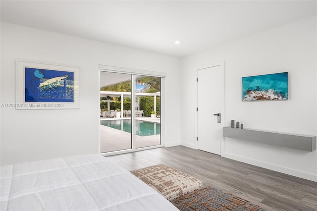 bedroom with access to outside and hardwood / wood-style flooring