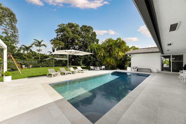 view of swimming pool with a patio and a lawn