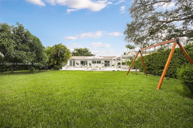 view of yard featuring a playground and a patio