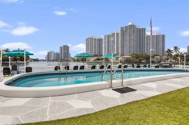 view of pool featuring a water view and a patio