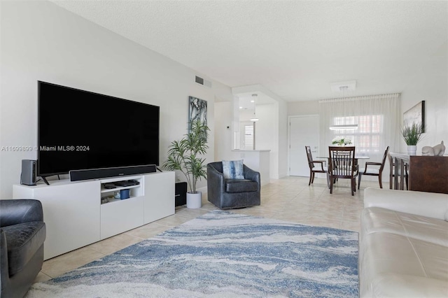 tiled living room featuring a textured ceiling