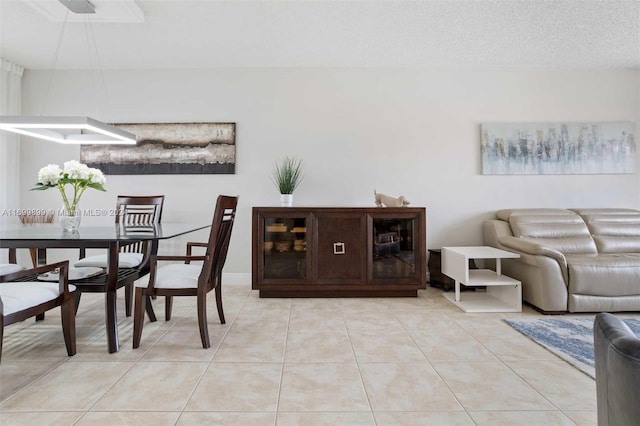 tiled dining space with a textured ceiling