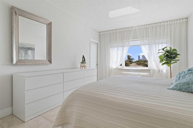 bedroom with light tile patterned floors and a textured ceiling