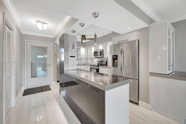 kitchen featuring a textured ceiling, white cabinets, decorative light fixtures, and appliances with stainless steel finishes