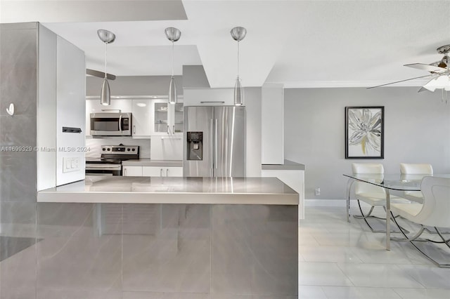 kitchen with white cabinets, hanging light fixtures, ceiling fan, appliances with stainless steel finishes, and kitchen peninsula