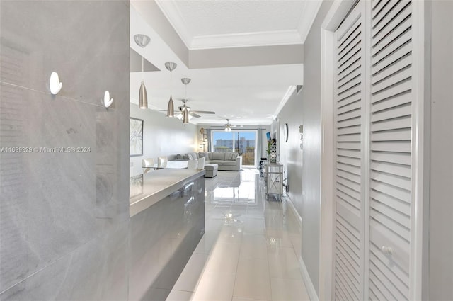 hall with light tile patterned floors, a textured ceiling, and crown molding