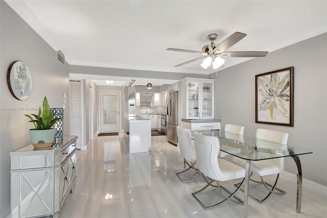 dining room featuring ceiling fan, crown molding, and light tile patterned flooring