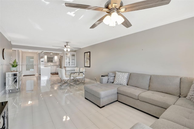 living room featuring ceiling fan, light tile patterned flooring, baseboards, and crown molding