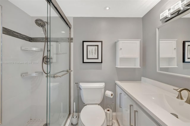 bathroom with vanity, toilet, and a shower with shower door