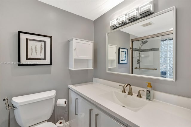 bathroom featuring vanity, toilet, and a shower with door