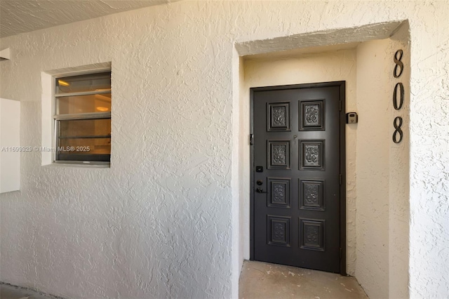 doorway to property featuring stucco siding