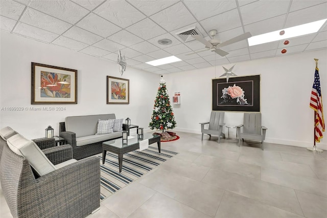 living room featuring a paneled ceiling and light tile patterned floors