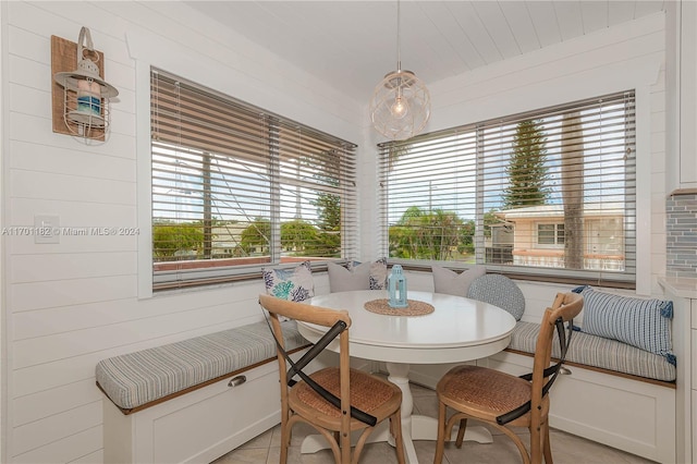 tiled dining room with wooden walls and breakfast area