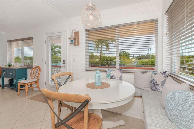 dining space with a textured ceiling, breakfast area, and light tile patterned flooring