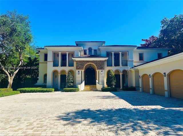 mediterranean / spanish home with a garage and a balcony