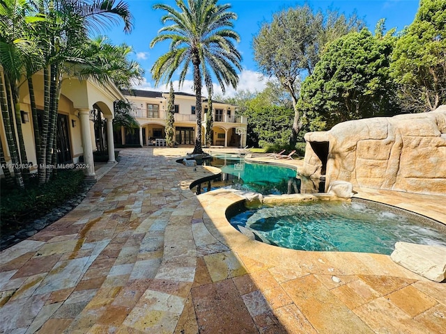 view of swimming pool featuring an in ground hot tub