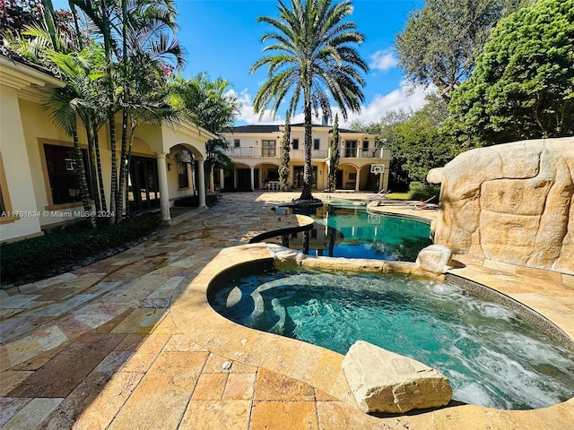 view of swimming pool featuring a patio area and an in ground hot tub