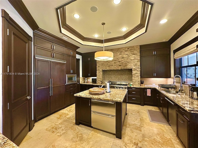 kitchen with light stone counters, sink, built in appliances, a center island, and hanging light fixtures