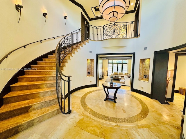 stairs featuring a high ceiling and a notable chandelier