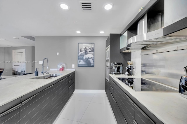 kitchen featuring sink, light tile patterned floors, stainless steel appliances, and wall chimney range hood