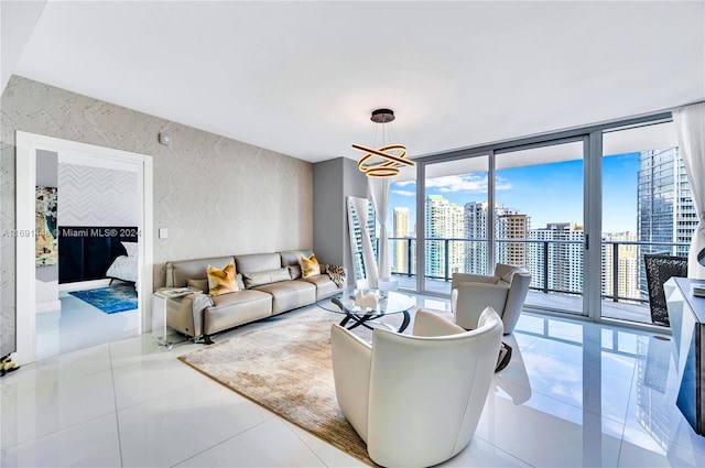 living room featuring light tile patterned floors, expansive windows, and a notable chandelier