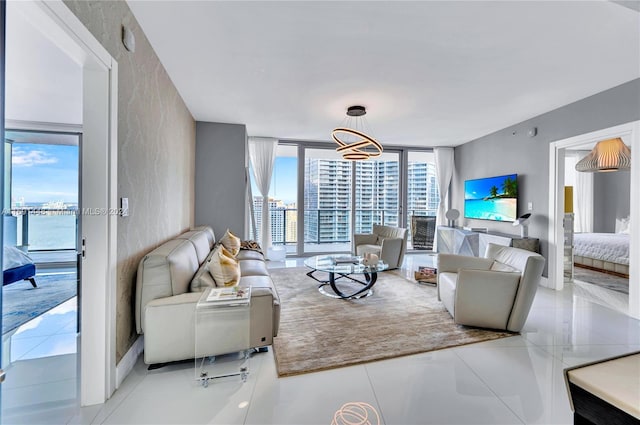 tiled living room with plenty of natural light, expansive windows, and a water view