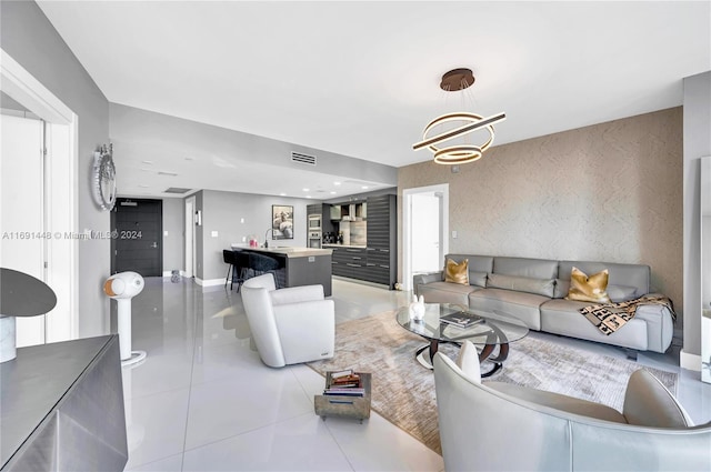 tiled living room with a notable chandelier and sink