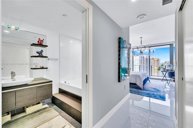 bathroom featuring a washtub, vanity, and an inviting chandelier