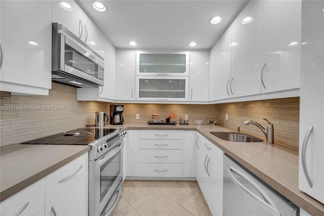 kitchen featuring stainless steel appliances, white cabinetry, tasteful backsplash, and sink