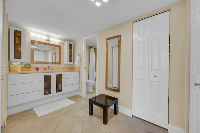 bathroom featuring tile patterned flooring, vanity, and toilet