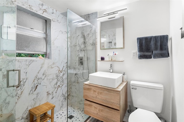 bathroom with an enclosed shower, vanity, and toilet