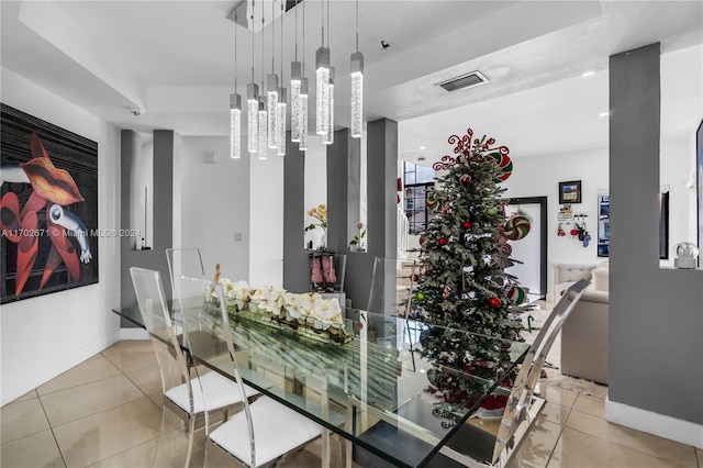 tiled dining room with an inviting chandelier