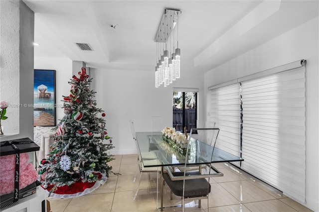 tiled dining area with an inviting chandelier