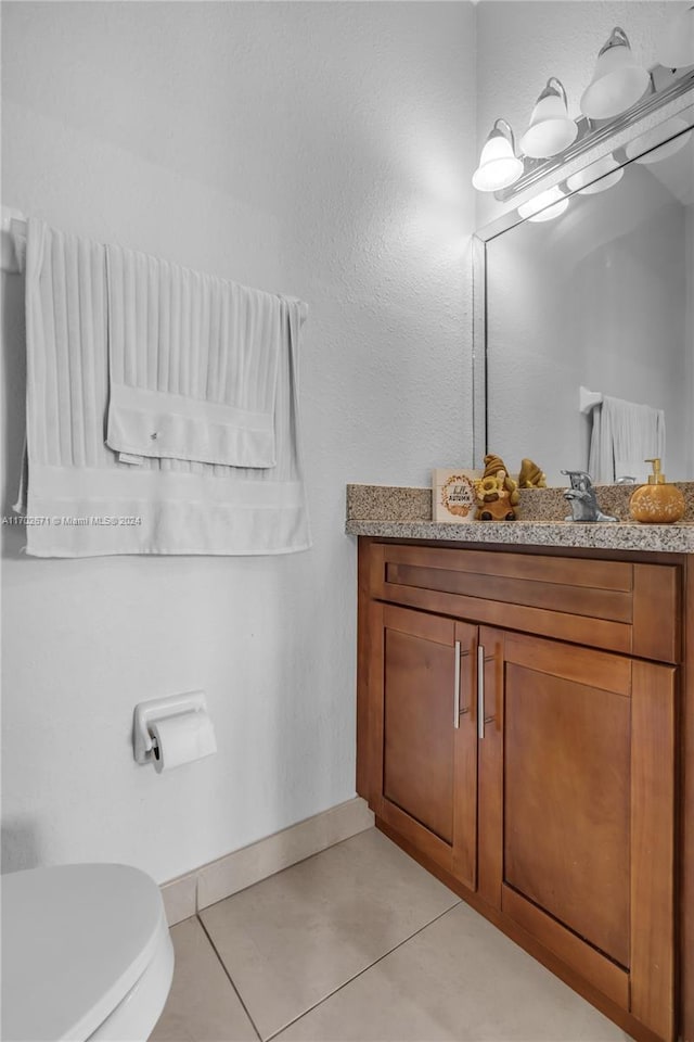 bathroom featuring tile patterned floors, vanity, and toilet