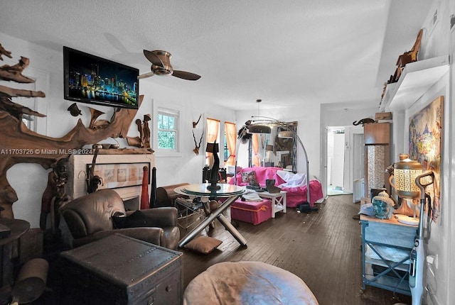 living room featuring a textured ceiling, dark hardwood / wood-style flooring, and ceiling fan