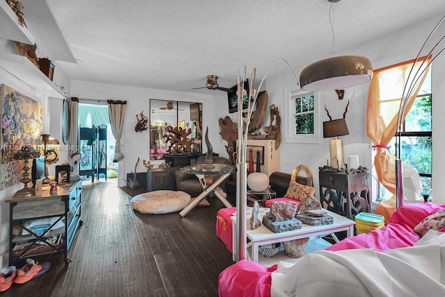 living room featuring hardwood / wood-style floors, plenty of natural light, ceiling fan, and a textured ceiling