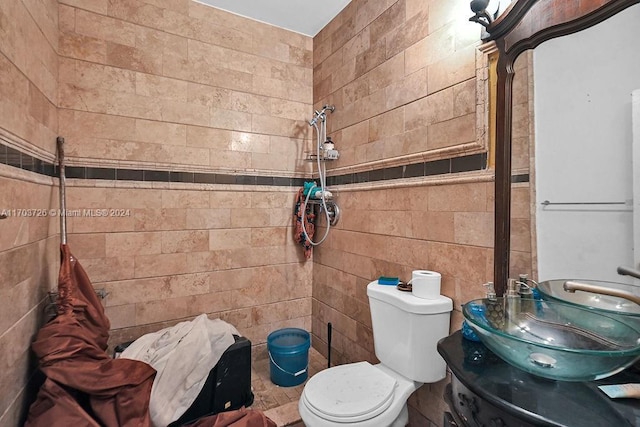 bathroom with vanity, toilet, and tile walls