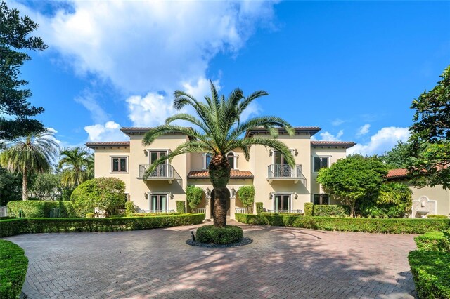 5935 Moss Ranch Rd, Pinecrest, FL 33156 - mediterranean / spanish house with french doors, a balcony, a tiled roof, and stucco siding