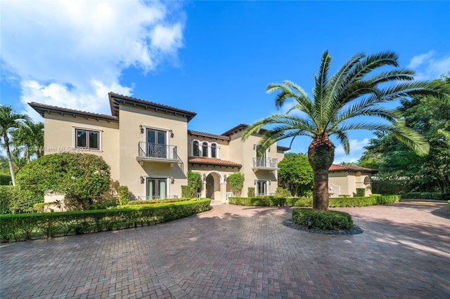 5935 Moss Ranch Rd, Pinecrest, FL 33156 - mediterranean / spanish home featuring a balcony, french doors, stucco siding, curved driveway, and a tile roof