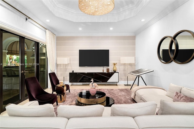 living room with a tray ceiling, an inviting chandelier, and ornamental molding