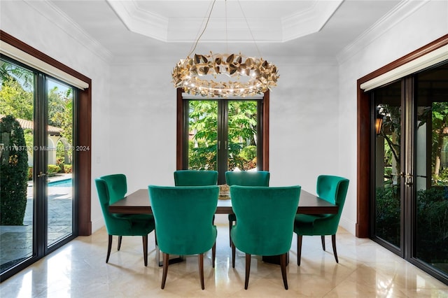 dining area featuring french doors, a tray ceiling, crown molding, and a notable chandelier