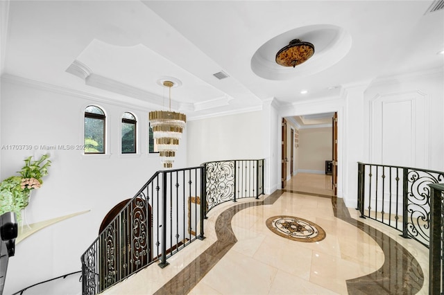 corridor featuring a tray ceiling, crown molding, a notable chandelier, and light tile patterned flooring