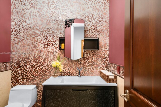 5935 Moss Ranch Rd, Pinecrest, FL 33156 - half bathroom with tile walls, decorative backsplash, vanity, and toilet