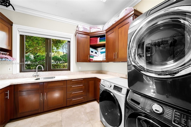 clothes washing area featuring cabinets, sink, stacked washer and dryer, ornamental molding, and light tile patterned flooring