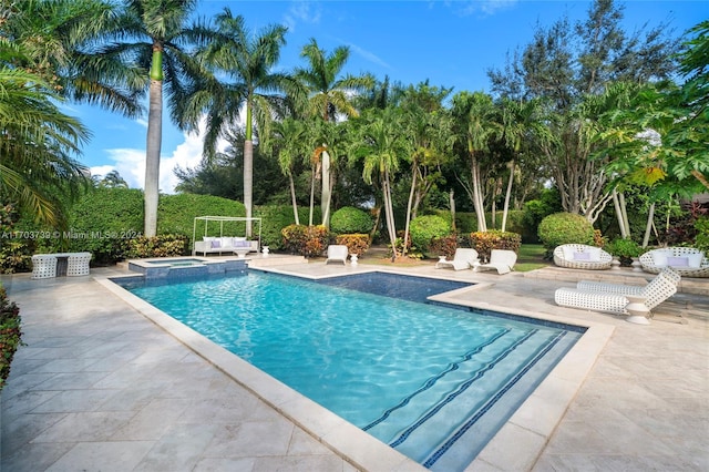 view of swimming pool featuring an in ground hot tub and a patio