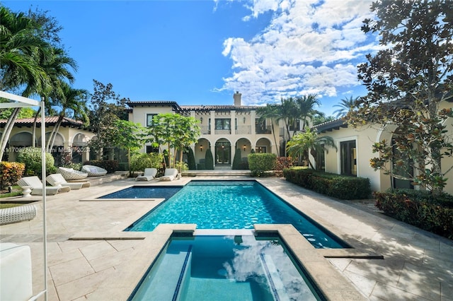 view of swimming pool featuring an in ground hot tub and a patio