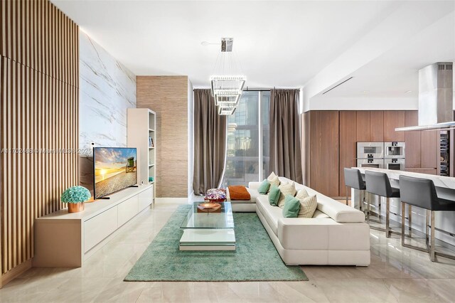 kitchen featuring island exhaust hood, a kitchen bar, sink, decorative light fixtures, and a large island