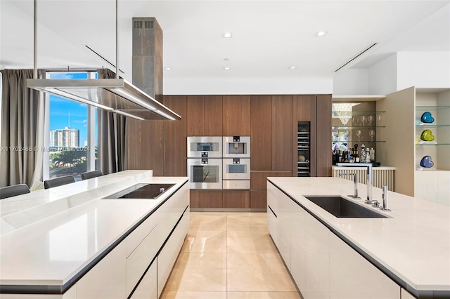 kitchen with white cabinetry, sink, a center island, stainless steel double oven, and black electric cooktop