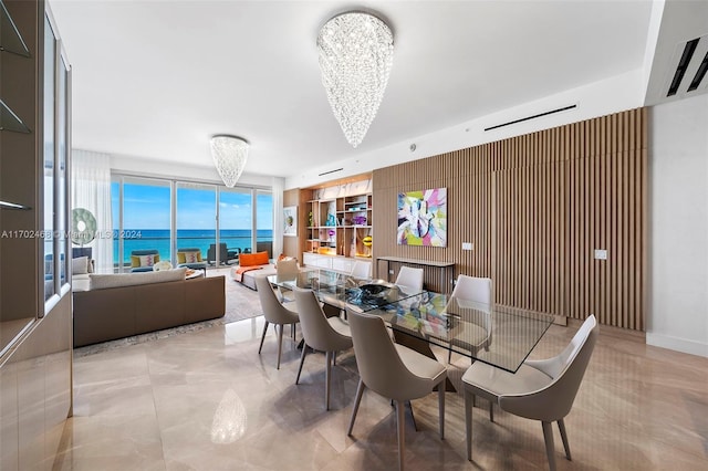 dining room featuring a water view, a wall of windows, and a chandelier