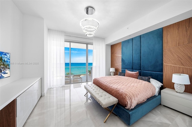 bedroom with a water view, access to outside, a notable chandelier, and light tile patterned flooring